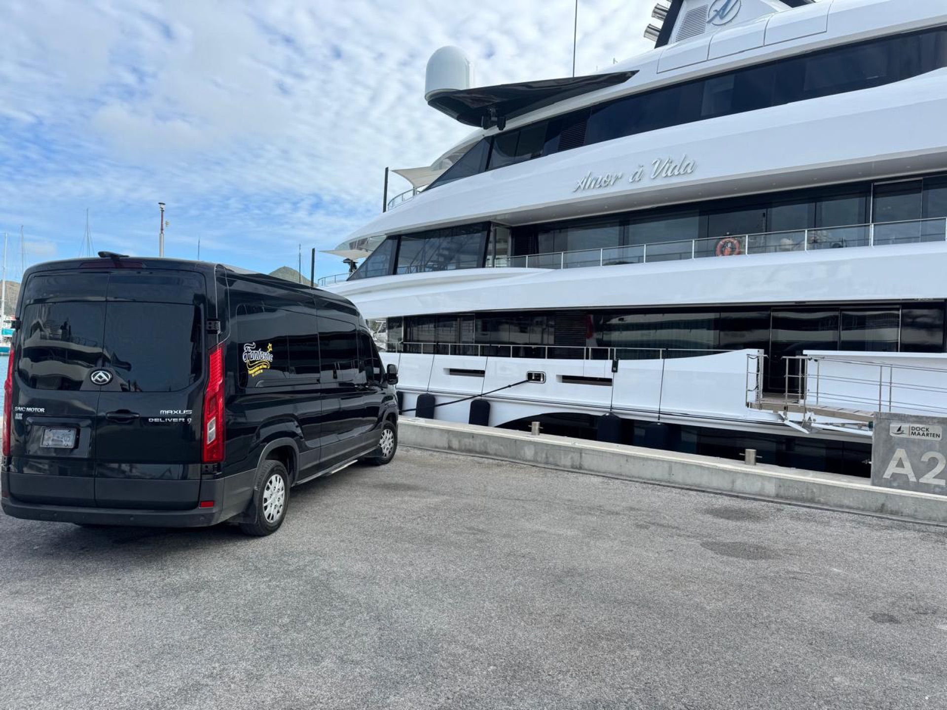 Black Johnson Fantastic Transport van parked beside a luxury superyacht at the Sint Maarten marina