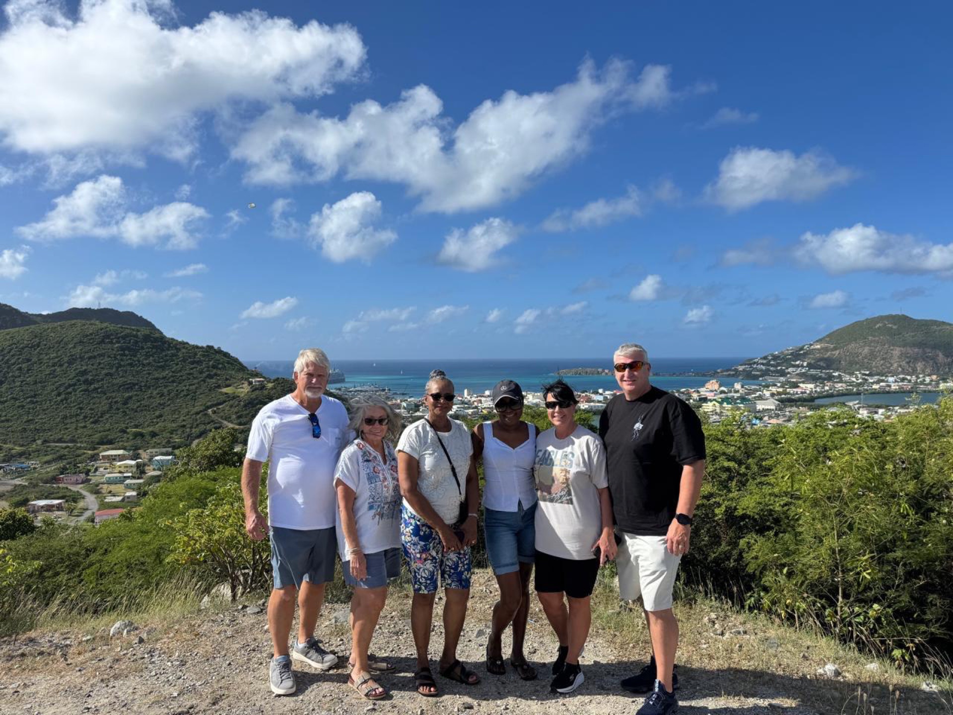 Happy tour group at a hilltop viewpoint overlooking Simpson Bay on a Sint Maarten island tour